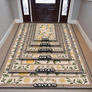 K&ouml;nnte beinhalten: Eine Auswahl rechteckiger Teppiche in verschiedenen Gr&ouml;&szlig;en mit einem Zitronen- und Bl&auml;ttermuster. Die Teppiche reichen von 61 cm x 91 cm bis 198 cm x 299 cm. Sie haben einen beigen Rand und einen hellen Hintergrund mit gelben Zitronen und gr&uuml;nen Bl&auml;ttern.