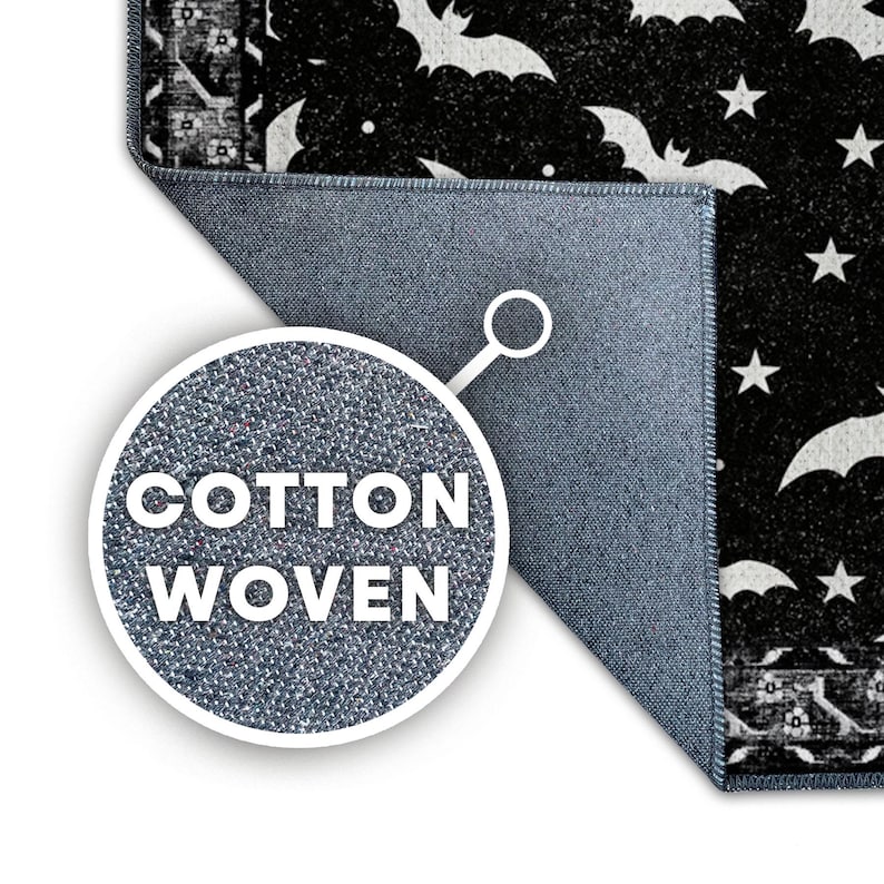 May include: Black and white Halloween-themed rug with a pattern of bats and stars. The rug is cotton woven, with a blue backing. The rug's design includes the text "COTTON WOVEN".