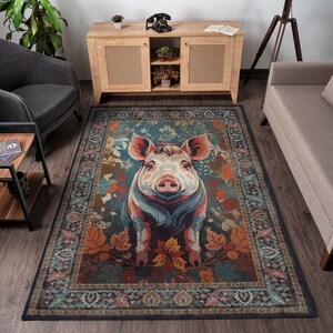 May include: A rectangular area rug featuring a large, colorful illustration of a pig. The pig is surrounded by autumn leaves and floral elements, set against a teal background. The rug has a decorative border with a traditional pattern.
