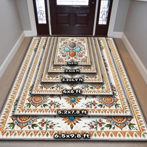 May include: A rectangular area rug featuring a white background with a central floral medallion pattern in shades of blue, orange, and green, bordered by a geometric orange and white triangle design. Text labels indicate sizes 2x3 ft to 6.5x9.8 ft.