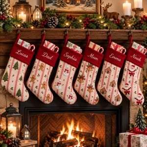 Può includere: Sei calze natalizie color crema con strisce verticali rosse e motivi festivi tra cui pini, omini di pan di zenzero, pupazzi di neve, campane, casette di pan di zenzero e Babbo Natale, ognuna con un risvolto rosso e un nome ricamato.
