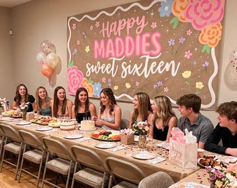 May include: A sweet sixteen party with a banner that reads "Happy Maddies Sweet Sixteen." The banner is decorated with flowers and stars. A long table is set with food, plates, and flowers. Several people are seated around the table.
