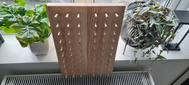 May include: A wooden pegboard with rows of dowels, perfect for hanging items like jewelry, tools, or keys.