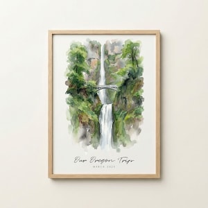 May include: Watercolor print of a waterfall scene with a bridge, framed in a light wood. Lush green foliage surrounds the cascading water. The text "Our Oregon Trips" and "March 2025" are written in a script font at the bottom.