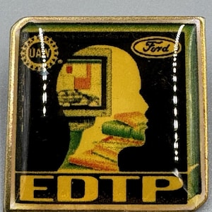 May include: A square metal pin with a gold-toned border featuring a black background. The design includes a yellow silhouette of a human head containing a computer monitor graphic, the text Ford, a UAW logo, and the large yellow text EDTP at the bottom.