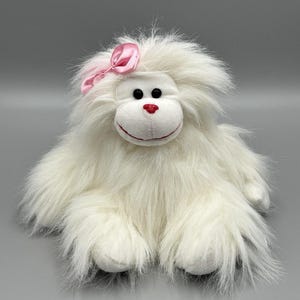 May include: A handmade wooden sign with the text "Welcome" in a handwritten style. The sign is painted white with a distressed finish, and a small green leaf is attached to the top. The background is a rustic wooden surface.