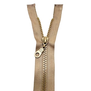 Può includere: Una cerniera dorata con un cursore in metallo. La cerniera è aperta e i denti sono visibili.