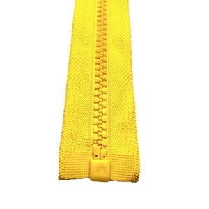 Op de afbeelding: Een gele rits met een gele plastic treklip die "SFS" zegt.