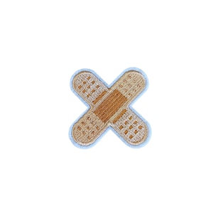 Könnte beinhalten: Ein hellblauer gestickter Patch in Form eines Verbandes mit brauner Mitte.