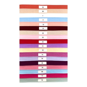 May include: A collection of 17 fabric swatches in various colors, including red, pink, blue, purple, and beige. Each swatch has a number printed on it, ranging from 1 to 80.