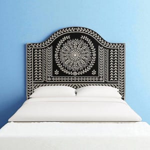 Op de afbeelding: Zwart en wit hoofdbord met een bloemen- en bladerontwerp. Het hoofdbord staat boven een wit bed met wit beddengoed. Het hoofdbord is ongeveer 152 cm breed.