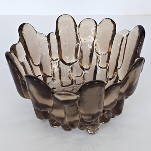 May include: A brown glass bowl with a unique, textured design. The bowl is shaped like a flower with many petals.