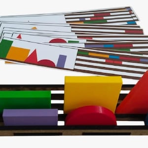 Puede incluir: Un juego de juguetes educativos de madera con formas geométricas coloridas y tarjetas a juego. Las formas incluyen un rectángulo verde, un prisma morado, un semicírculo rojo, un cuadrado amarillo, un triángulo rojo y un cubo azul. Las tarjetas tienen patrones coincidentes.