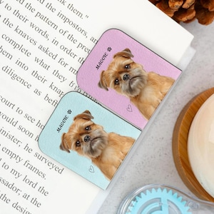 May include: Two rectangular dog-themed bookmarks. One is light blue, the other is lavender. Each features a close-up of a brown dog's face, the name "MAGGIE" and a paw print. A small heart is also visible on each bookmark.