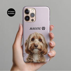 Könnte beinhalten: Eine lavendelfarbene Handyhülle mit einem Porträt eines braunen und cremefarbenen Hundes. Der Name "Maggie" und ein Pfotenabdruck sind über dem Bild des Hundes aufgedruckt. Ein kleines Herz ist auf der Hülle gezeichnet. Der Text "16 Farben verfügbar" steht in einem schwarzen Kreis.