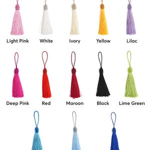 May include: A collection of colorful tassels in various shades, including light pink, white, ivory, yellow, and lilac. Other colors are deep pink, red, maroon, black, lime green, ocean blue, light blue, and royal blue. Each tassel has a loop and a decorative bead.