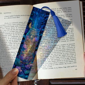 May include: A bookmark with a blue tassel features a jar filled with colorful flowers and butterflies. The jar is set against a background of a blue and purple floral design, with text visible.