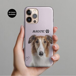 May include: A light purple phone case featuring a dog portrait with the name "Maggie" and a paw print. The case also has a small heart and the text "16 Colors Available".