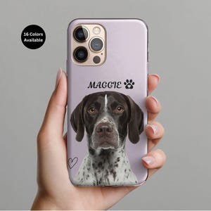 May include: A lilac phone case featuring a German Shorthaired Pointer dog portrait with the name "Maggie" and a paw print. A small black heart is drawn on the case. The text "16 Colors Available" is in a black circle in the upper left corner.