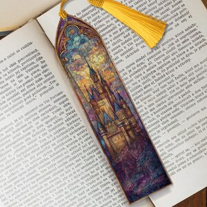 May include: A bookmark with a castle stained-glass design and a yellow tassel. The illustration features a detailed castle scene with a colourful, intricate design, ideal for marking pages in a book.