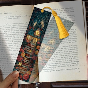 Puede incluir: Marcapáginas decorativo con una ilustración detallada de un edificio, libros y rosas. Una borla amarilla cuelga de la parte superior. El marcapáginas mide aproximadamente 18 cm de largo.