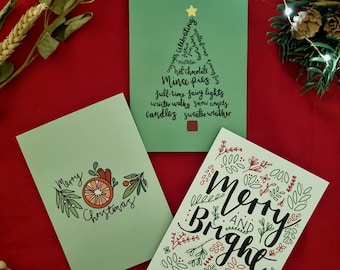 May include: Three Christmas cards with green backgrounds and festive designs. The first card features a Christmas tree made of words related to the holiday season. The second card has a stylized orange and holly design with the text "Merry Christmas". The third card has a floral design with the text "Merry and Bright".