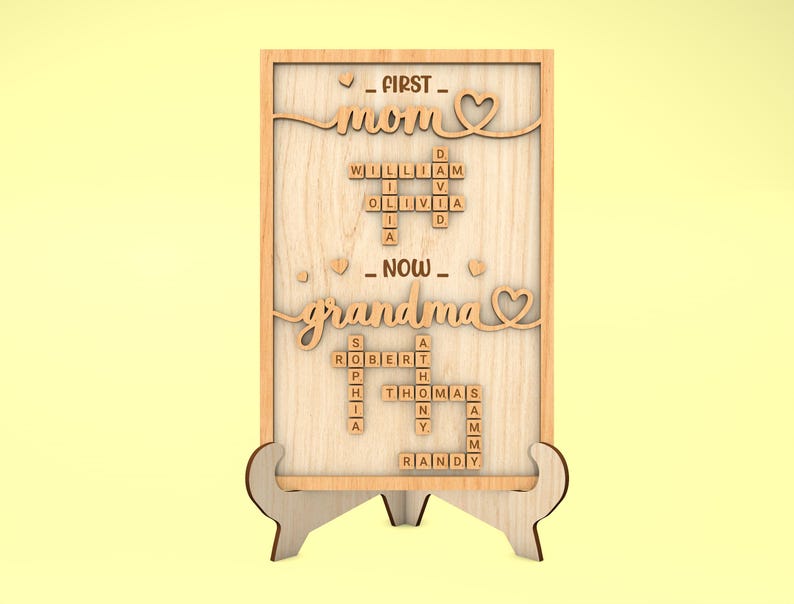 May include: Wooden sign with the words "FIRST MOM NOW GRANDMA" spelled out using Scrabble tiles. The sign is on a small wooden stand.