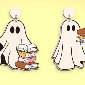 Op de afbeelding: Een paar witte geestoorbellen met een stapel boeken in hun handen. De geest links houdt een stapel van vier boeken vast, terwijl de geest rechts twee boeken vasthoudt.