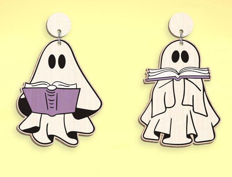 Op de afbeelding: Twee witte spookornamenten met zwarte ogen en monden. Een spook houdt een paars boek vast en het andere houdt een wit boek vast met de tekst "Read" erop.