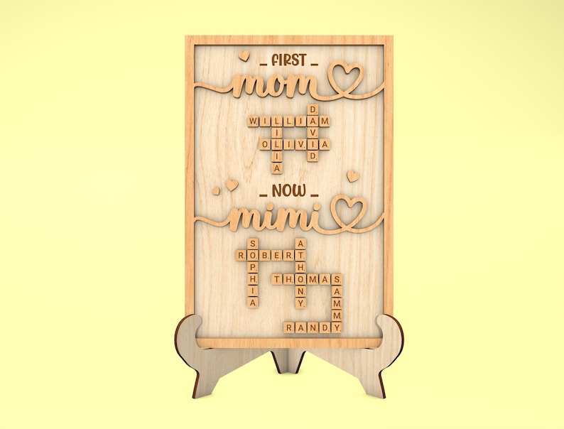 May include: Wooden sign with the words "First Mom" and "Now Mimi" in a scrabble tile design. The sign is on a small wooden stand.