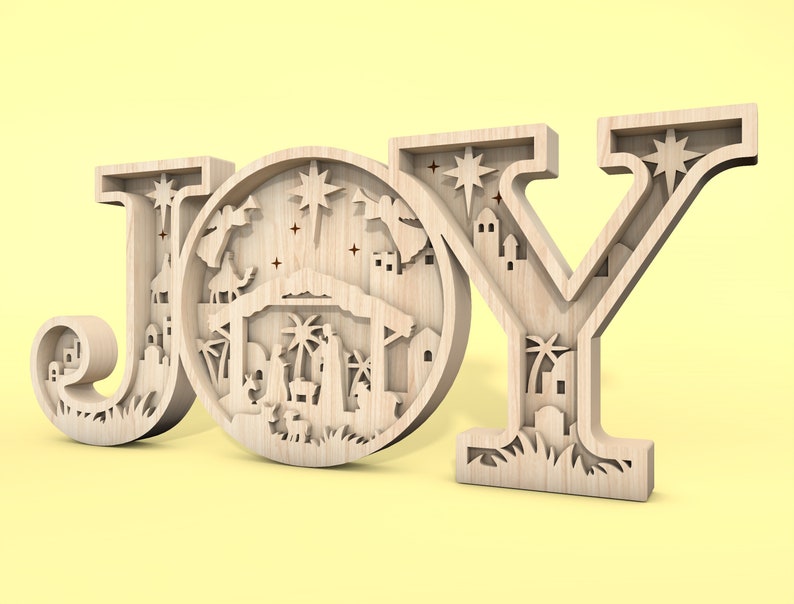 May include: Wooden JOY sign with a detailed nativity scene cutout in the centre of the O. The scene includes a stable, a star, palm trees, and figures of Mary, Joseph, and baby Jesus.