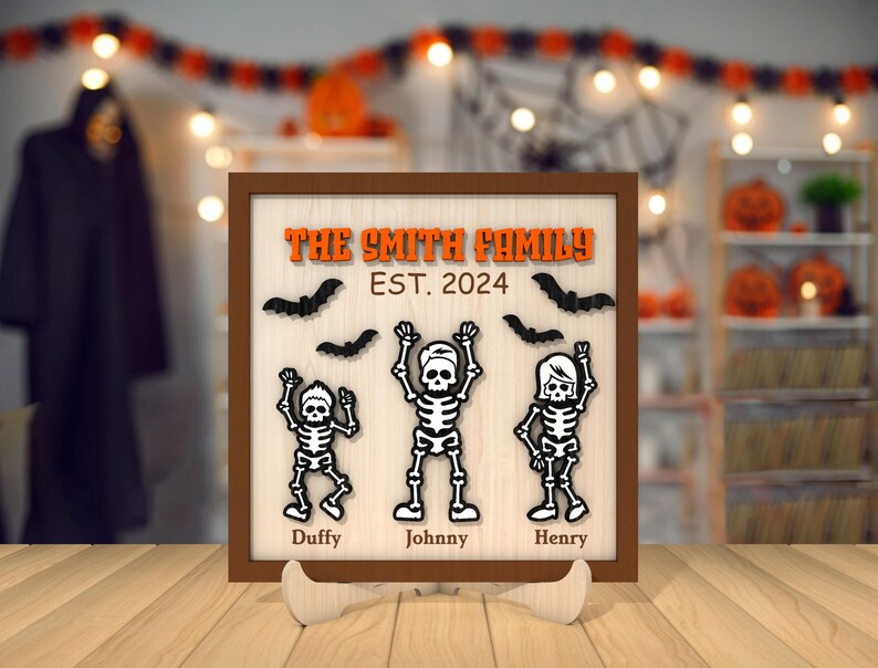 May include: A brown wooden sign with the text "The Smith Family Est. 2024" and three black skeleton figures with the names "Duffy", "Johnny", and "Henry" underneath.