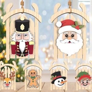 May include: Wooden Christmas ornaments in the shape of sleds, each featuring a different holiday character. The ornaments include a nutcracker, Santa Claus, a reindeer, a gingerbread man, a snowman, and an elf. Each ornament is made of light-colored wood.