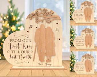 May include: Wooden heart-shaped plaque with a couple's silhouette and the text "From our first kiss till our last breath". The plaque is on a wooden stand and has the names "Jack" and "Jenny" engraved below the couple's silhouette.