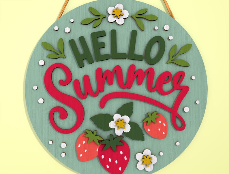 K&ouml;nnte beinhalten: Runder Holzschild mit den Worten "HELLO Summer" in gr&uuml;ner und roter Schrift. Das Schild zeigt Erdbeeren, wei&szlig;e Blumen und gr&uuml;ne Bl&auml;tter. Ein beiges Seil ist zum Aufh&auml;ngen befestigt. Der Hintergrund ist hellt&uuml;rkis.