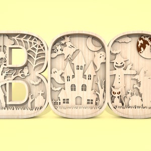 Könnte beinhalten: Ein Holzausschnitt des Wortes "BOO" mit Halloween-Motiven. Das "B" zeigt ein Spinnennetz, eine Spinne, einen Baum und einen Vogelscheuche. Das "O" zeigt ein Spukhaus, einen Geist und eine Fledermaus. Das "O" zeigt einen Vogelscheuche, eine Katze, eine Hexe und einen Kürbis.