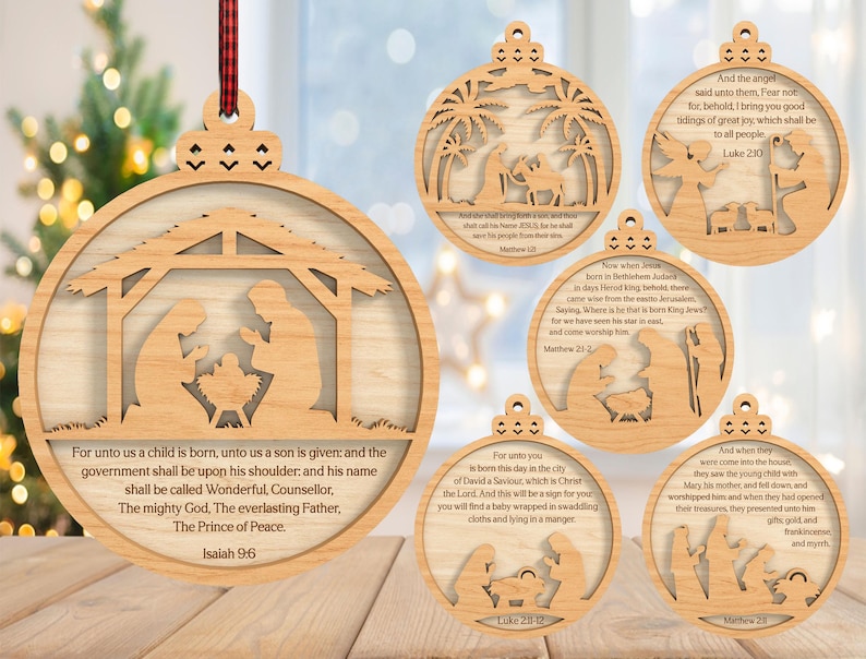 May include: Wooden Christmas ornaments with Nativity scenes. Each ornament is round with a cutout design and a scripture quote. The ornaments are made of light-colored wood and have a small hole at the top for hanging. A red and black plaid ribbon is attached to one.