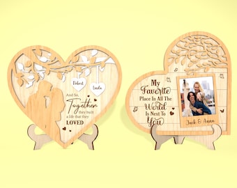May include: Two wooden heart-shaped plaques with engraved text and a photo. The first plaque features a tree with branches and leaves, and the text "And So, Together they built a life that they LOVED". The second plaque features a tree with branches and leaves, and the text "My Favorite Place In All The World Is Next To You". A photo of a couple is in the center of the second plaque with the text "Jack & Anna" below the photo.