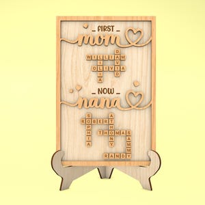May include: Wooden sign with the words "FIRST - mom" and "NOW - nana" spelled out with Scrabble tiles. The tiles are arranged in a crossword puzzle pattern.