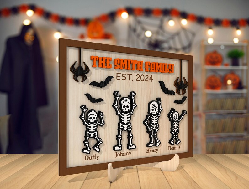 May include: A brown wooden sign with the text "The Smith Family Est. 2024" and five skeleton figures with names below them: "Duffy", "Johnny", "Henry", "Dennis". The sign has a Halloween theme with bats and spiders.
