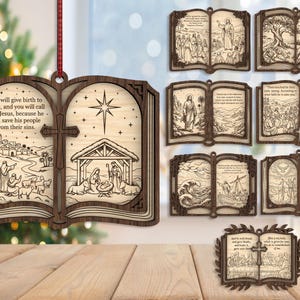 May include: A laser-cut wooden ornament shaped like an open book, featuring a nativity scene and the text: She will give birth to a son, and you will call him Jesus, because he will save his people from their sins. Includes a red ribbon.