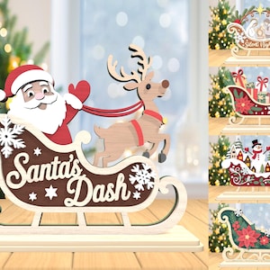 May include: Wooden Christmas decorations featuring Santa Claus in a sleigh pulled by a reindeer, with the text "Santa's Dash". Additional designs include a nativity scene, a sleigh with gifts, a snowman scene, and a sleigh with poinsettias.