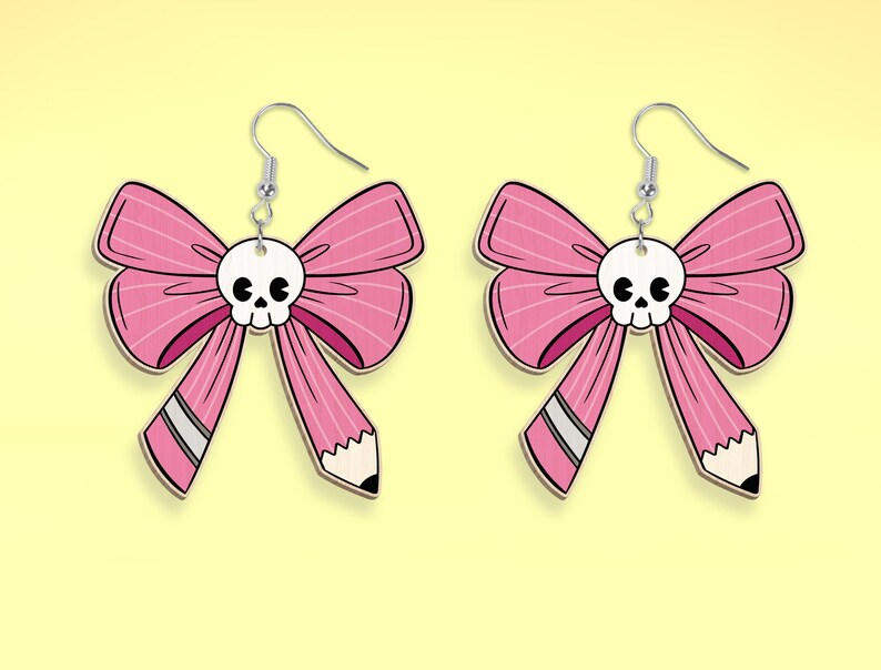 May include: A pair of pink bow earrings with a white skull charm in the center of each bow. The bows are shaped like pencils with a white eraser at the end.
