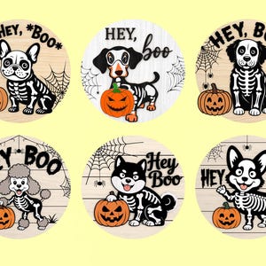 Może przedstawiać: Kolekcja sześciu drewnianych kręg&oacute;w o tematyce Halloween. Każdy przedstawia inną rasę psa w kostiumie szkieletu, dynię i frazę "Hey Boo". Projekty są w kolorze czarnym i białym z pomarańczowymi akcentami.