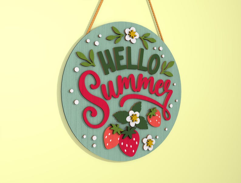 K&ouml;nnte beinhalten: Runder Holzschild mit den Worten "HELLO Summer" in gr&uuml;ner und roter Schrift. Das Schild zeigt Erdbeeren, wei&szlig;e Blumen und gr&uuml;ne Bl&auml;tter auf hellblauem Hintergrund. Ein braunes Seil ist zum Aufh&auml;ngen befestigt.