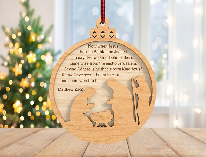 May include: Wooden Christmas ornament with a nativity scene cutout and the text "Now when Jesus born in Bethlehem Judaea...Matthew 2:1-2". The ornament is round with a decorative top and a red and black plaid ribbon for hanging.