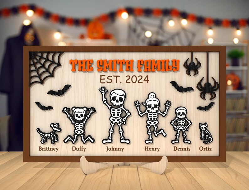 May include: A wooden sign with a Halloween theme featuring a family of skeletons. The sign reads "The Smith Family Est. 2024" and includes the names of each family member: Brittney, Duffy, Johnny, Henry, Dennis, and Ortiz.