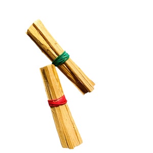 May include: Two bundles of dried sticks, tied together with rubber bands. One bundle is tied with a green rubber band, and the other is tied with a red rubber band.