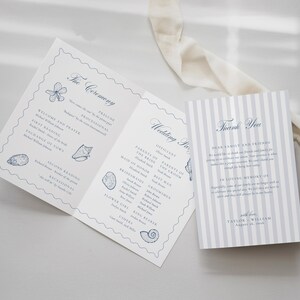 May include: A folded wedding program and a matching thank you card featuring blue text and seashell illustrations on white paper. The program lists ceremony details, while the striped thank you card includes a message from Taylor and William.