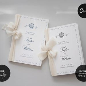 May include: Two white wedding program cards featuring a navy blue scallop shell illustration, elegant serif and script typography, and a decorative wavy border. Each card is tied with a cream-colored chiffon ribbon on the left side.